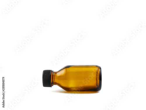 Small glass bottle lying horizontally empty pharmaceutical amber with black plastic cap for aromatherapy or mockup on white background