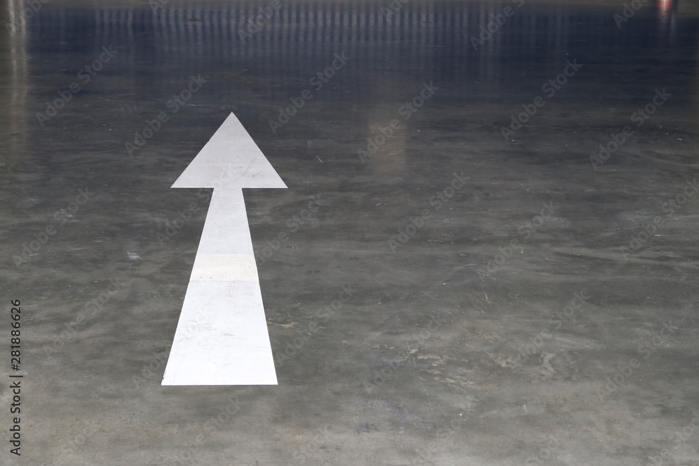 White arrow symbol on polished cement floor. White arrow symbol on polished cement floor.