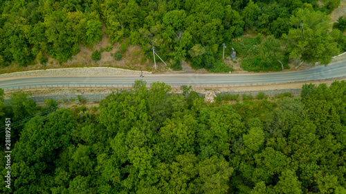 Amazing top down view of straight road between trees in the forest in Crimea