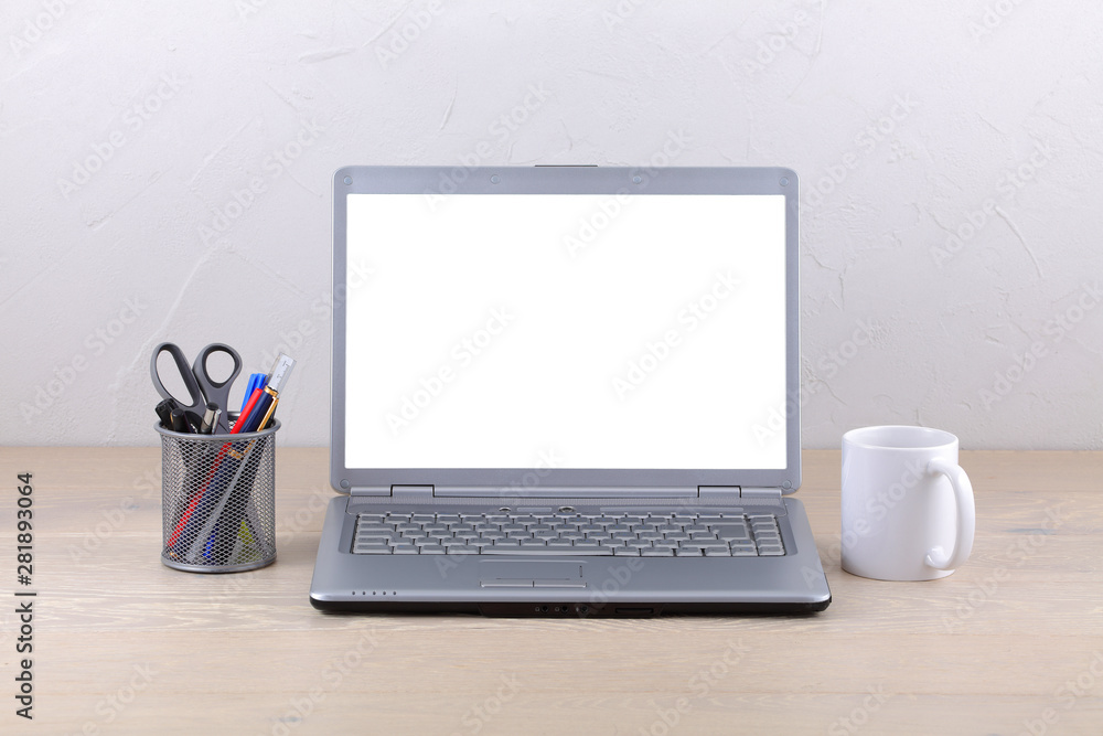 Fototapeta premium Laptop computer on office desk coffee mug and pens. White screen template with clipping path