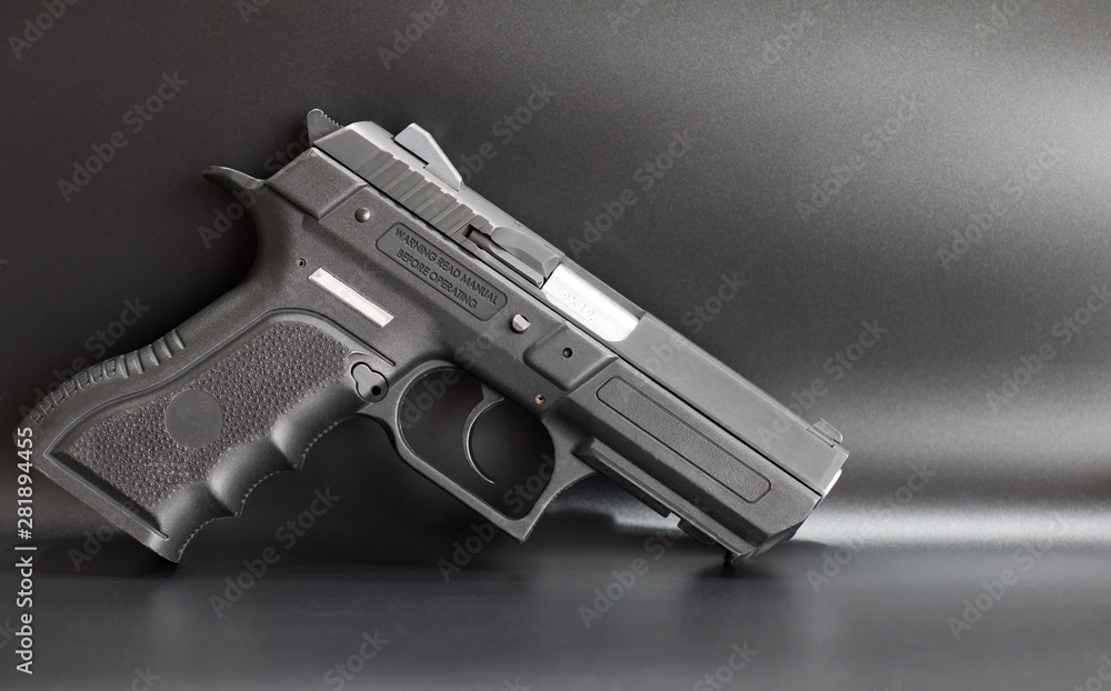 Black 9 mm pistol on a gray background Black 9 mm pistol on a gray background