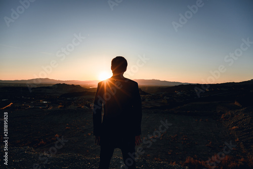 guy looking over valley at sunset