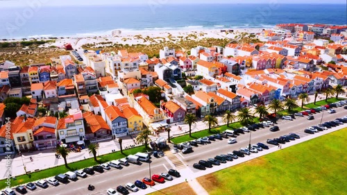 Gafanha da Encarnacao, Portugal. Aerial view of the famous Costa Nova colorful houses in Aveiro, Portugal. Time-lapse from above with car traffic and sea at the background