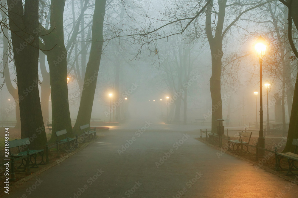 KRAKOW, POLAND - DECEMBER 06, 2015: Misty evening in Planty Park