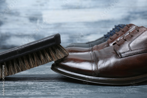 Men's leather shoes and cleaning brush on grey table