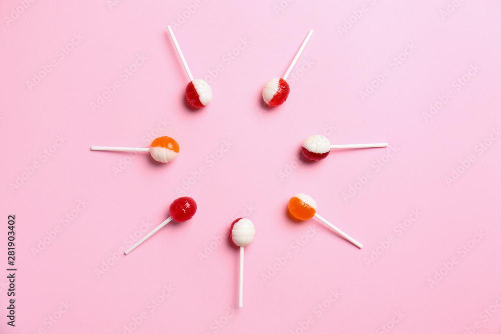 Flat lay composition with delicious lollipop candies on pink background. Space for text Flat lay composition with delicious lollipop candies on pink background. Space for text