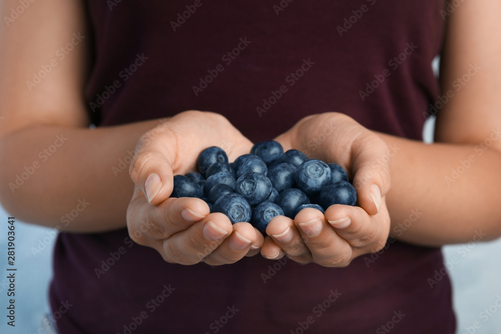 Young woman holding tasty ripe blueberries, closeup Young woman holding tasty ripe blueberries, closeup
