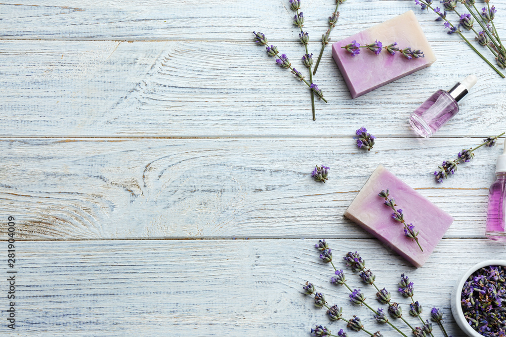 Obraz premium Flat lay composition of handmade soap bars with lavender flowers on white wooden background. Space for text
