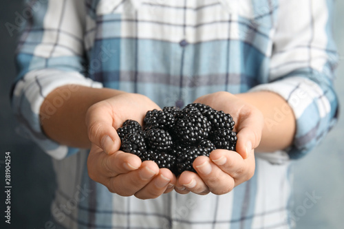 Young woman with handful of ripe blackberries, closeup