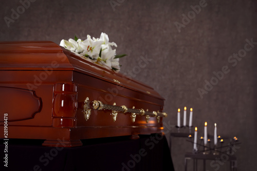 Tableau sur toile Wooden casket with white lilies in funeral home