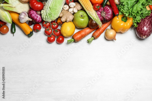 Different fresh vegetables on light table  flat lay. Space for text