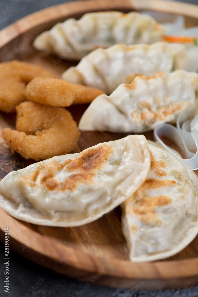 Close-up of fried potstickers and king shrimps in panko breading, selective focus, vertical shot