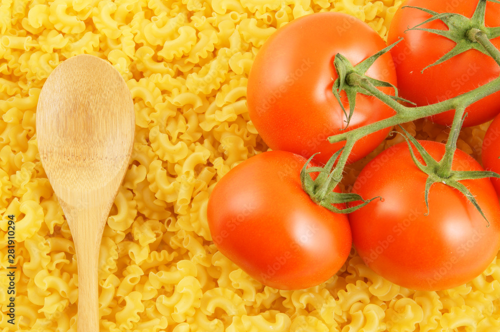 Macaroni background with wooden spoon and tomatoes Macaroni background with wooden spoon and tomatoes