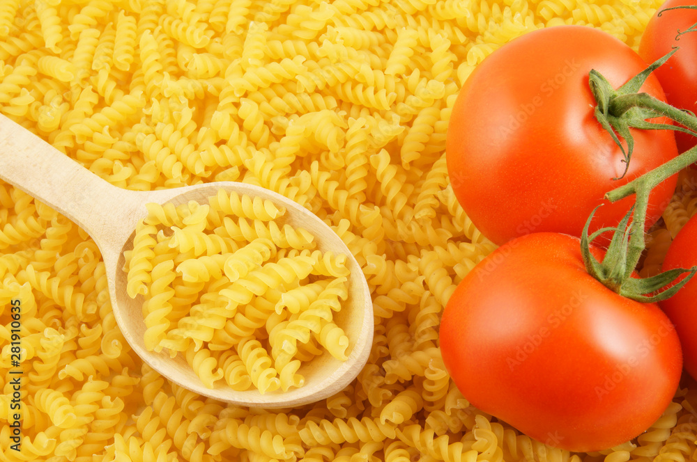 Pasta with wooden spoon and tomatoes