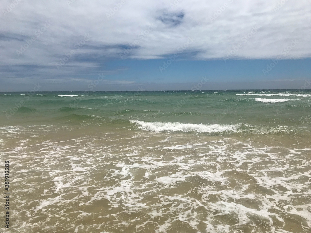 stunning white sand beach and crystal clear waters of southern europe in the algarve portugal on a cloudy day stunning white sand beach and crystal clear waters of southern europe in the algarve portugal on a cloudy day