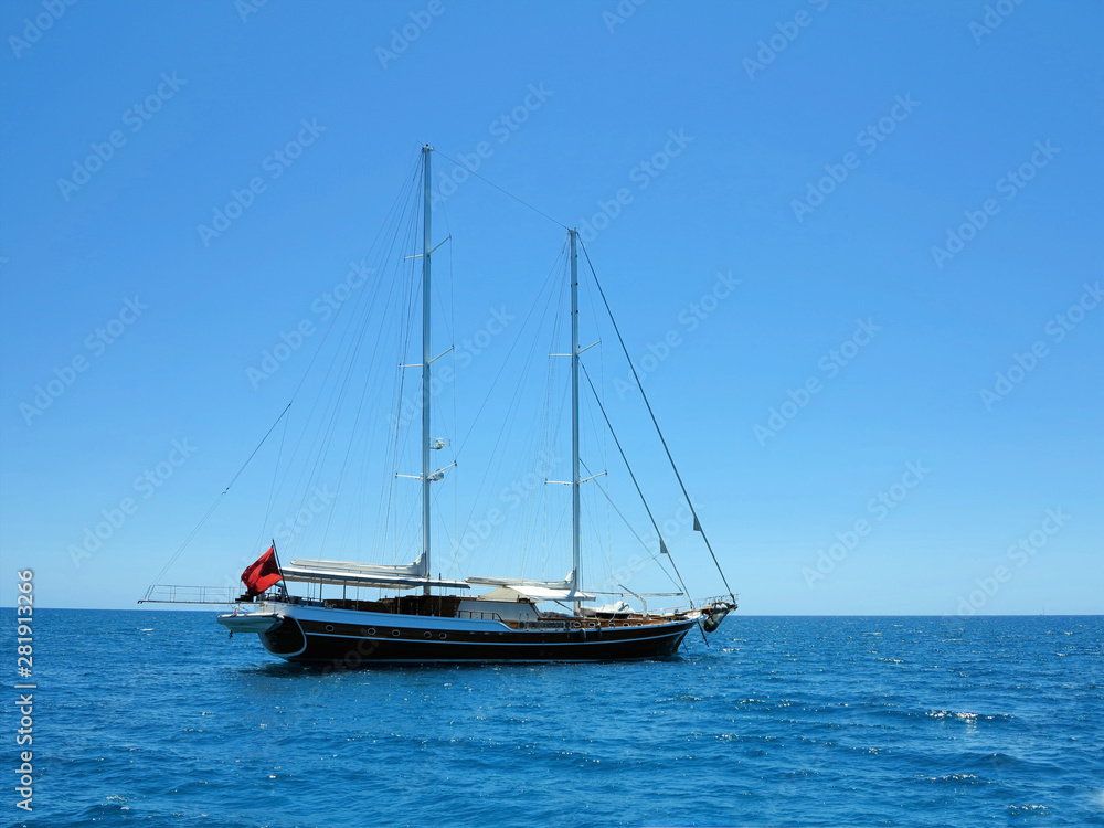 Sailing ship luxury brown wooden yacht in blue sea Sailing ship luxury brown wooden yacht in blue sea