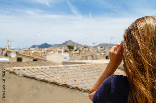 Fototapeta Naklejka Na Ścianę i Meble -  Junge Frau über den Dächern von Alcudia Mallorca Spanien Touristin Ausblick