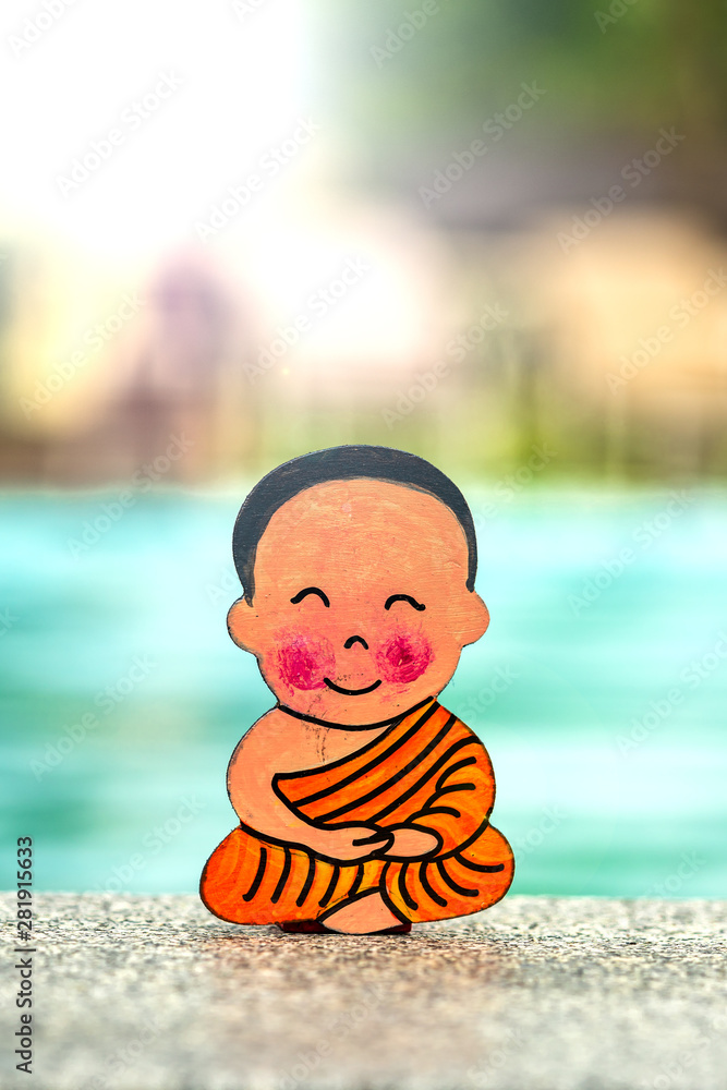 Little boy Buddhist, little Buddha, sitting on the sand by the pool at the hotel. Rejoice and smiles in the Lotus position. Meditation and relaxation.