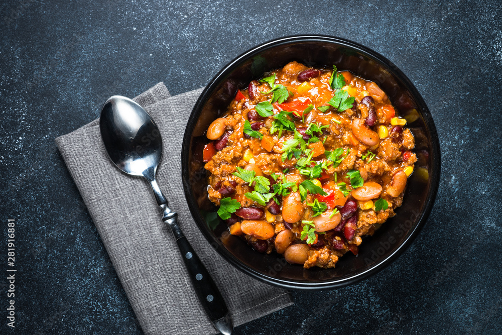 Chili con carne from meat and vegetables on black table top view Chili con carne from meat and vegetables on black table top view