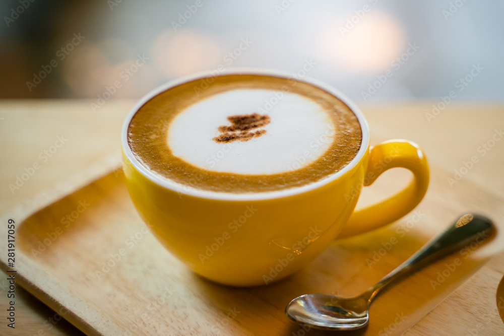 Hot cappucino with small spoon on the table Hot cappucino with small spoon on the table