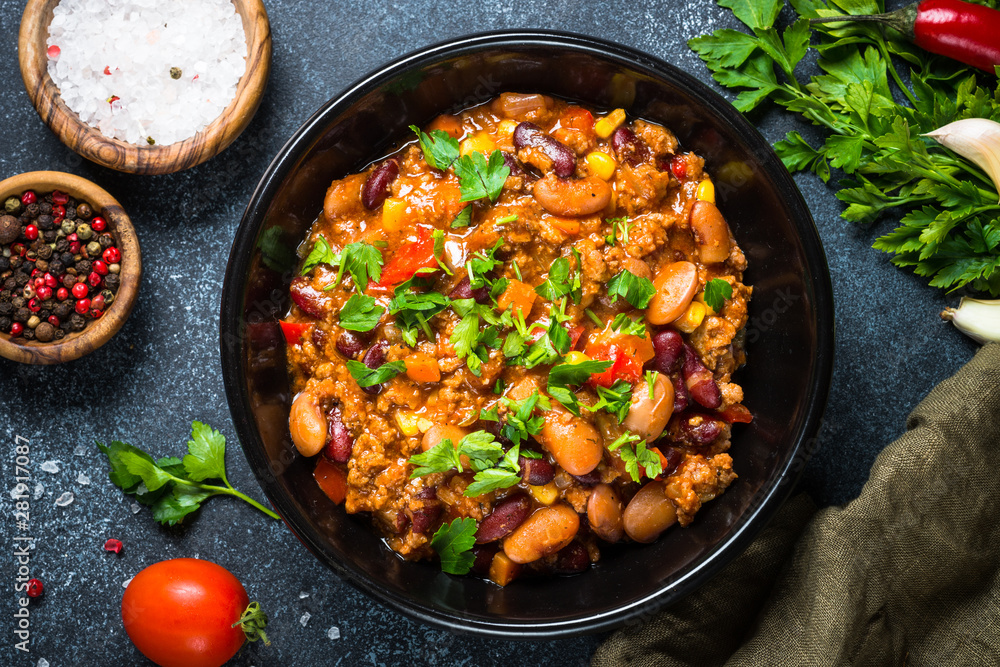 Chili con carne from meat and vegetables on black table top view Chili con carne from meat and vegetables on black table top view