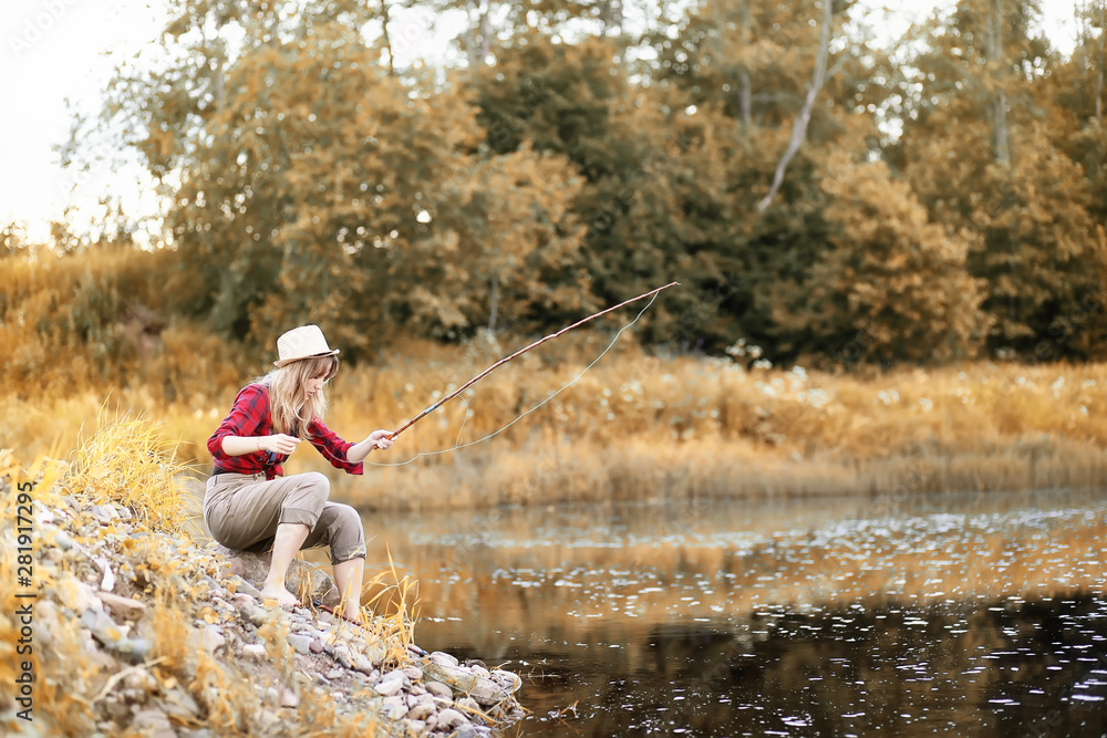 Girl in autumn with a fishing rod