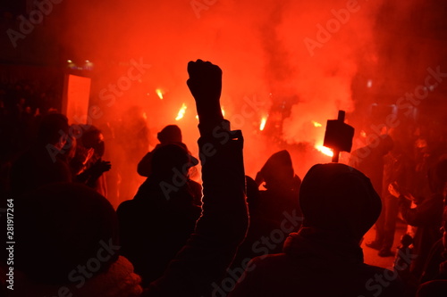 Protesters photographed during a night demonstration with red flash lights photo