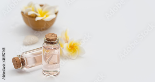 Spa wellness concept rose liquid bottle soap white stone and beautiful Plumeria flowers on white background