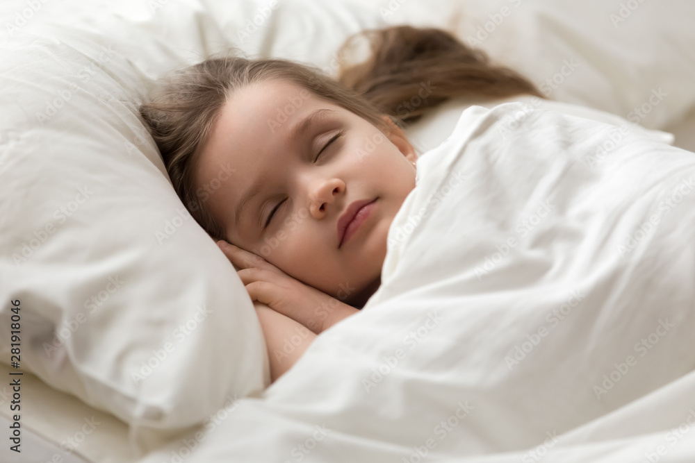 Closeup little girl covered with blanket sleeps sweetly in bed Closeup little girl covered with blanket sleeps sweetly in bed