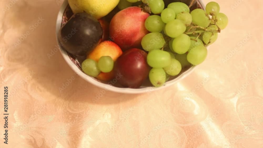 The camera a very slow approaches to fruits on plate at warm electric lamp lights The camera a very slow approaches to fruits on plate at warm electric lamp lights