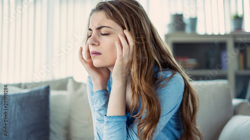 Young woman with headache in home