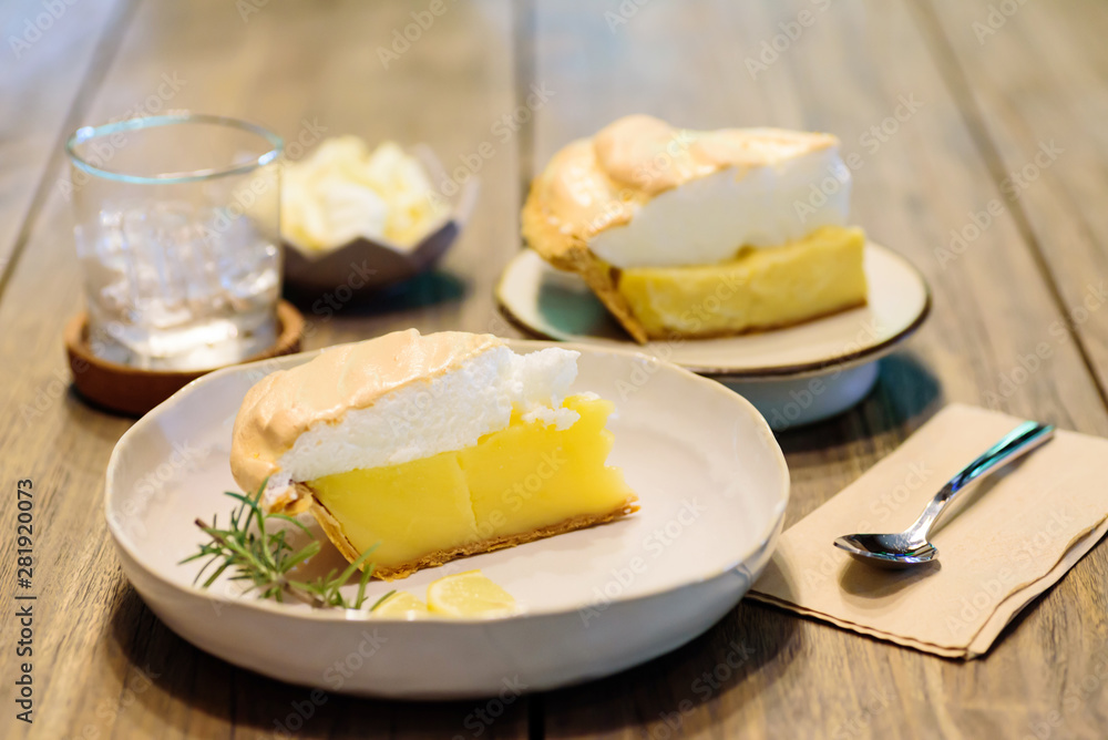Piece of lemon meringue pie on wooden table