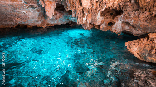 The crystal blue water in the rainbow cenote and orange cliffs