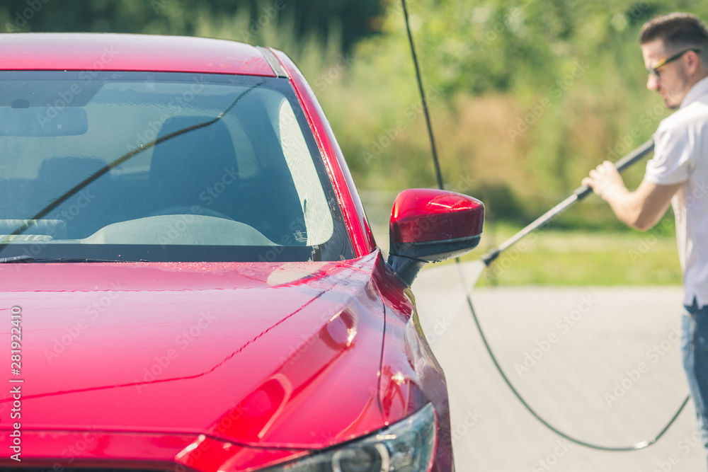 Manual car wash with pressurized water in car wash outside. Summer Car Washing. Cleaning Car
