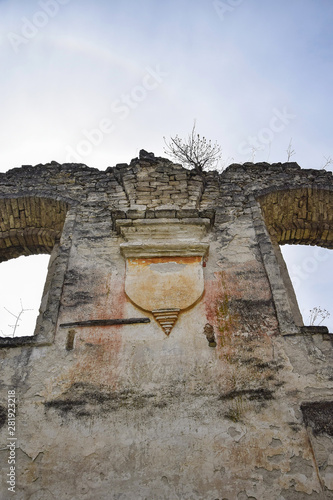 Religious symbol. Ruins of an ancient synagogue with arched windows, against the blue sky. Texture old dilapidated masonry. Tree growing on the wall. Rashkov, Moldova. Selective focus. Copy space. photo