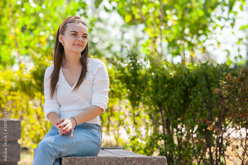 Young beautiful woman sitting on bench in park. Young beautiful woman sitting on bench in park.