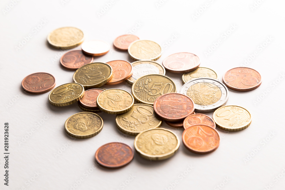 European Euro coins spilled on white surface European Euro coins spilled on white surface