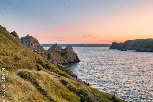 Beautiful peaceful Summer evening sunset beach landscape image at Three Cliffs Bay in South Wales