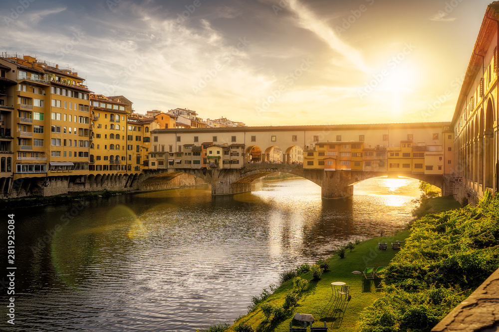 Ponte Vecchio bridge over Arno river in Florence city, Italy in the sunset