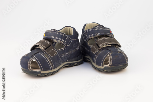 Old children's sandals in blue on a white background.