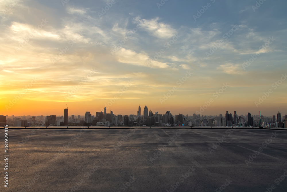 Selective focus of the cement floor with cityscape background in the evening at Bangkok , Thailand. Cement floor on the roof with sunset over the building in capital.