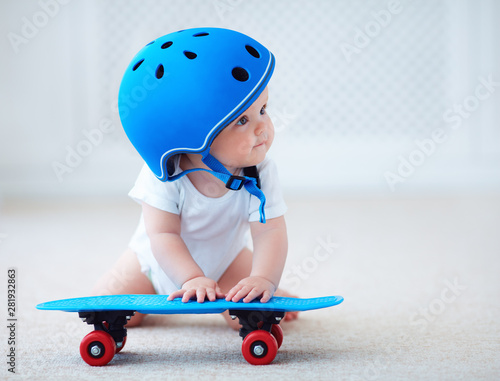Fototapeta cute infant baby girl in protective helmet outfit ready to ride skateboard, extr