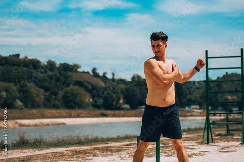 Athletic man during workout stretching in park © qunica.com