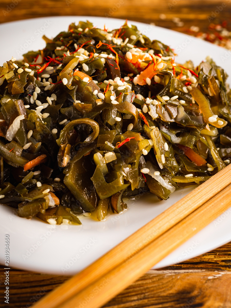 Seaweed salad with sesame seeds is on a white plate
