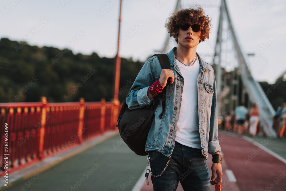 Obraz premium Young man with backpack is standing outdoors