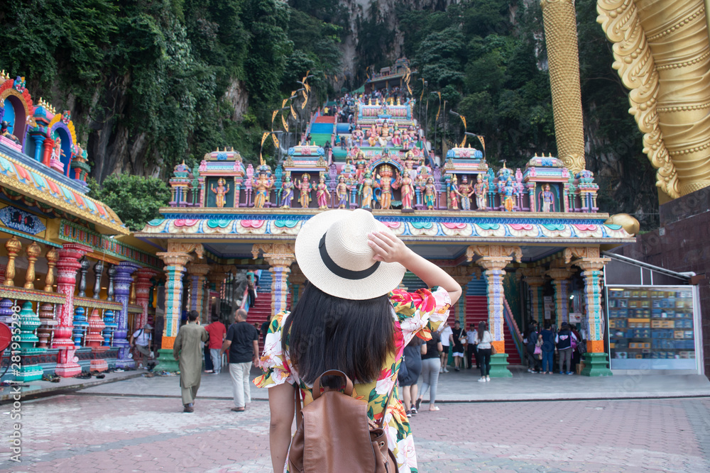 Fototapeta premium Turystka zwiedza świątynię hinduistyczną jaskini Batu w Kuala Lumpur w Malezji.