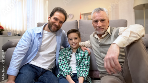 Φωτογραφία Multiage male family members looking to camera, family demography statistics