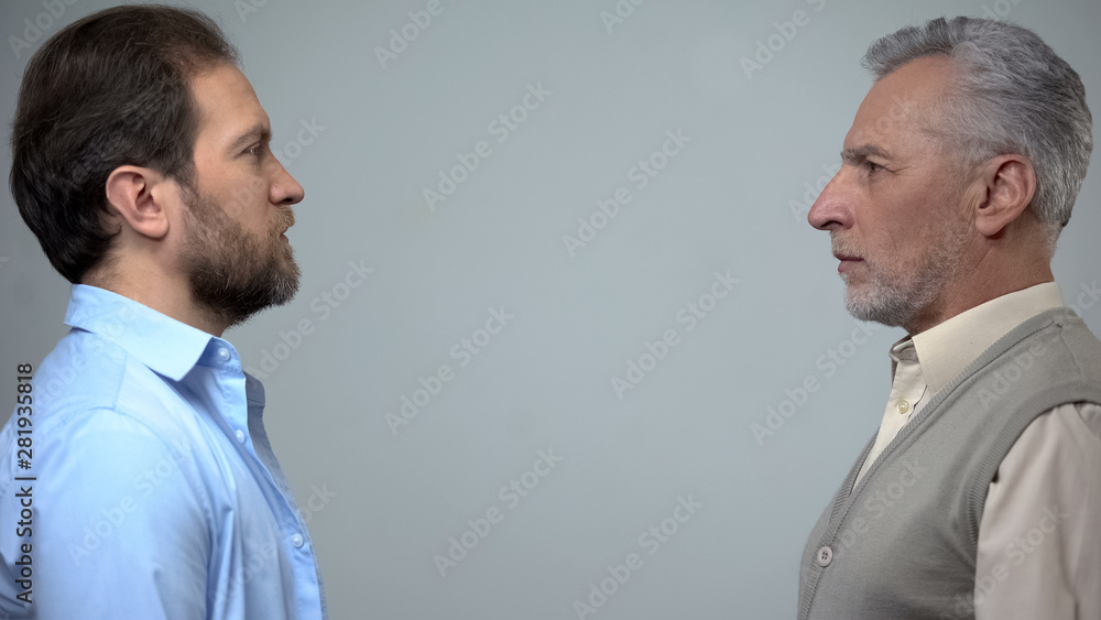 Senior and middle-aged men staring each other, male health, present and future Senior and middle-aged men staring each other, male health, present and future