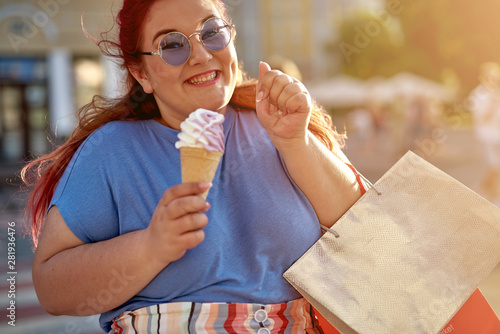 Fat woman holding shopping bag and ice cream