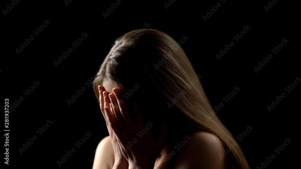 Frightened woman crying, hiding face behind palms, women rights protection Frightened woman crying, hiding face behind palms, women rights protection